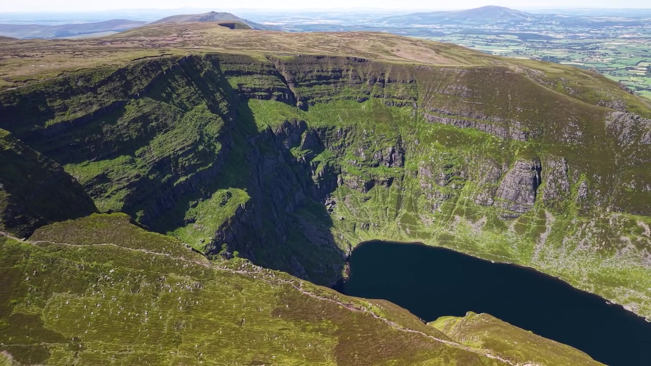 Dramatisk luftfoto av Coumshingaun botnsjø under ruvende klipper, Irland.