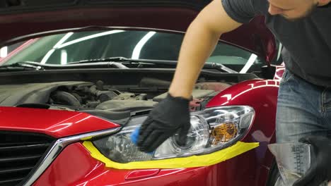 headlight polishing, processing of car lights. a car service worker polishes the headlight of a passenger car. professional polishing.