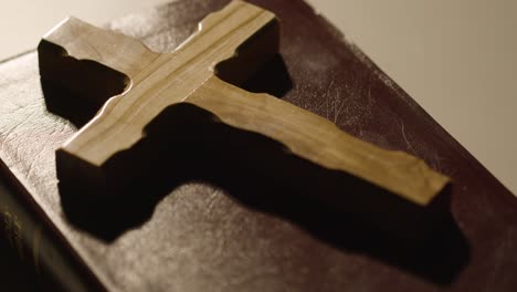 religious concept shot with close up of person wooden cross onto cover of bible