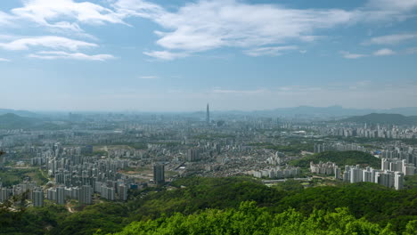 El-Horizonte-De-La-Ciudad-De-Seúl-Con-El-Movimiento-De-Las-Nubes-En-Primavera,-Vista-De-La-Torre-Lotte-World-Desde-La-Cima-De-La-Montaña-De-Las-Fortalezas-Namhansanseong