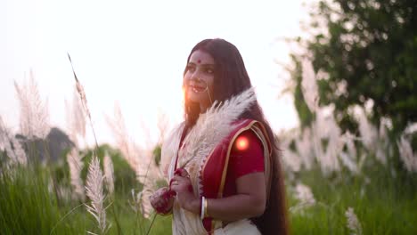 una hermosa y pensativa mujer india es feliz y piensa en algo de manera tranquila en un campo al atardecer o al amanecer