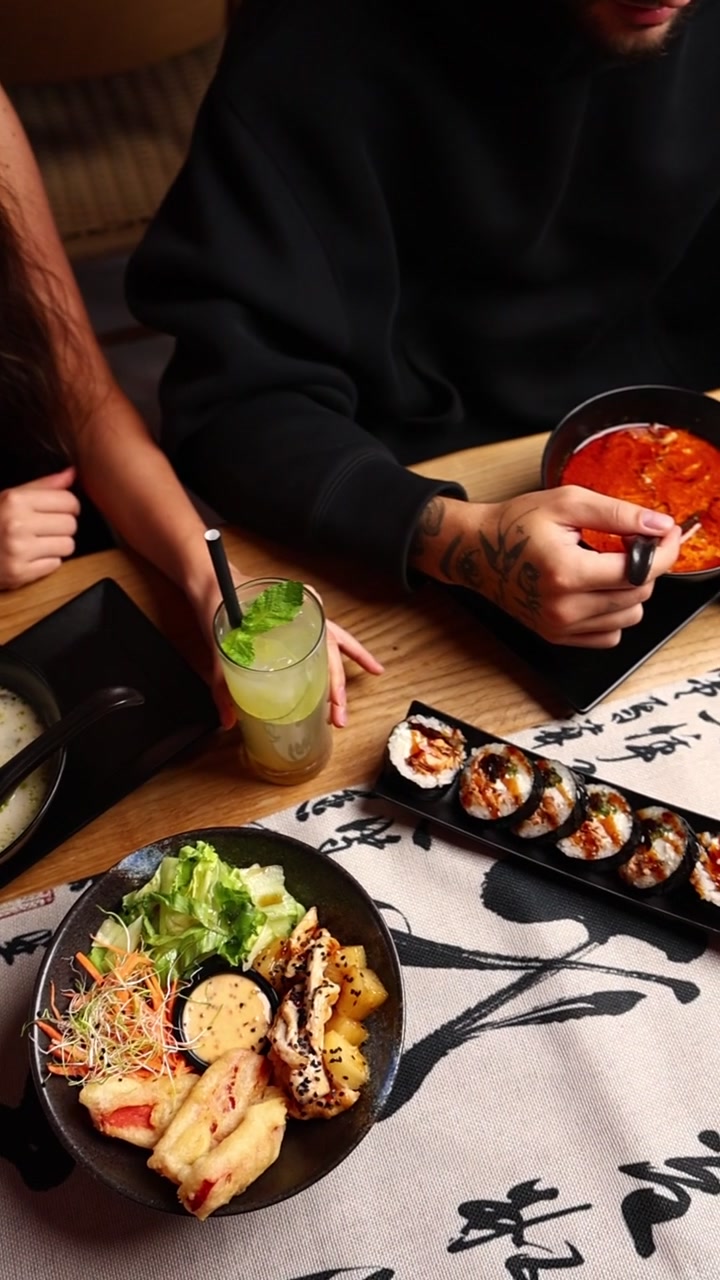 Casal Desfrutando de Culinária Japonesa em uma Mesa de Restaurante