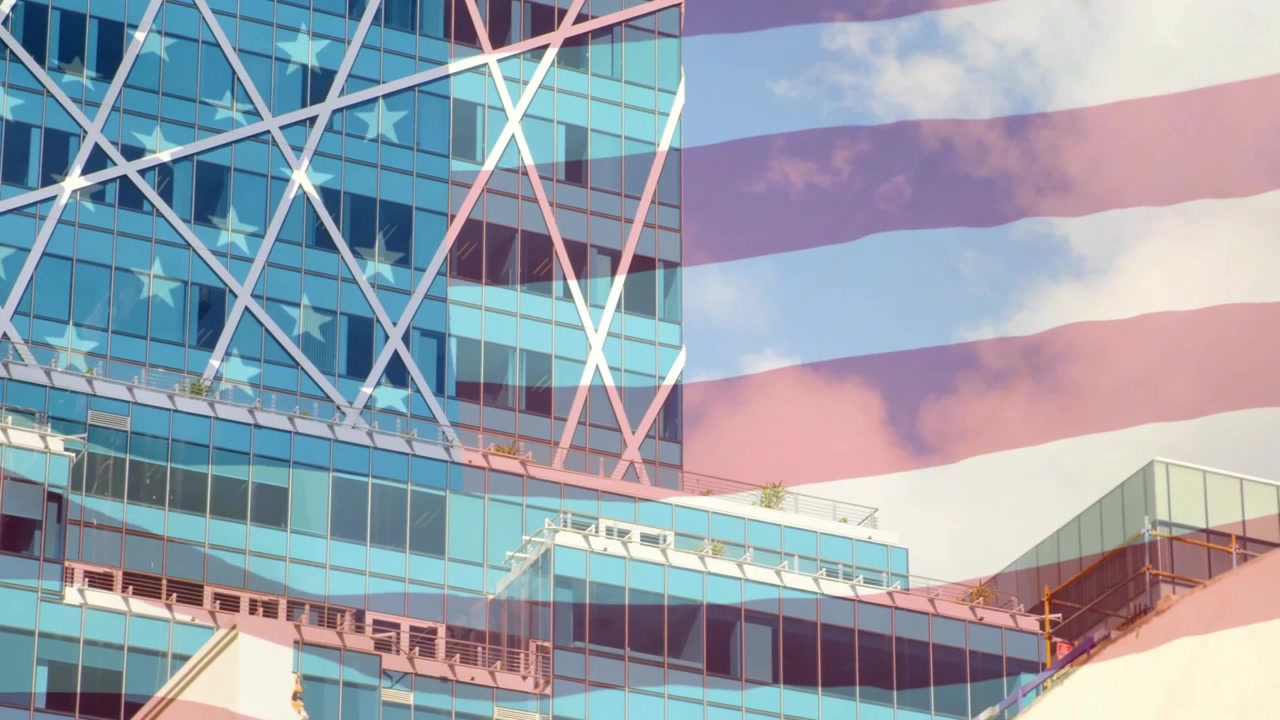 Sobreposição de bandeira americana surgindo e tremulando sobre um arranha-céu de vidro, representando patriotismo