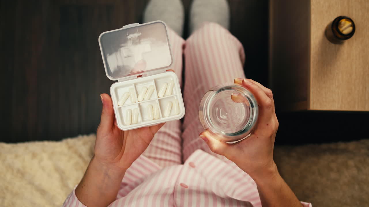 잠옷을 입고 약을 먹는 여자