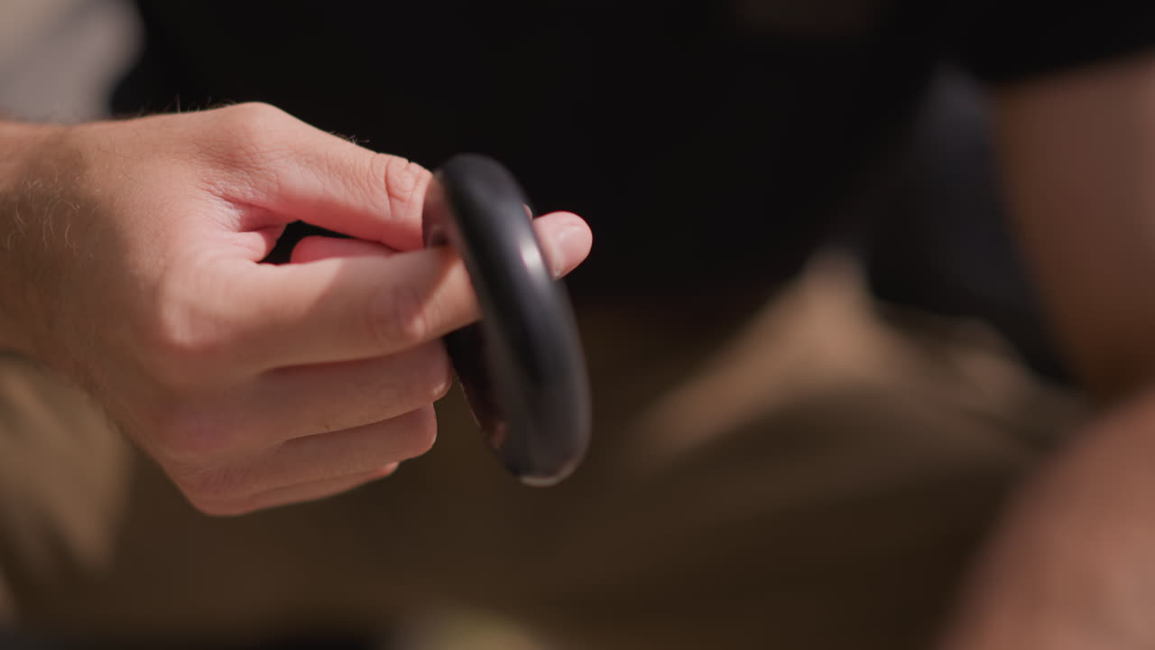 Rehabilitation Hand Training, Closeup Of Man Demonstrating Manual Dexterity Exercise, Focused Scene Of Male Performing Finger Motion Exercises Using Rubber Ring In Comfortable Living Space