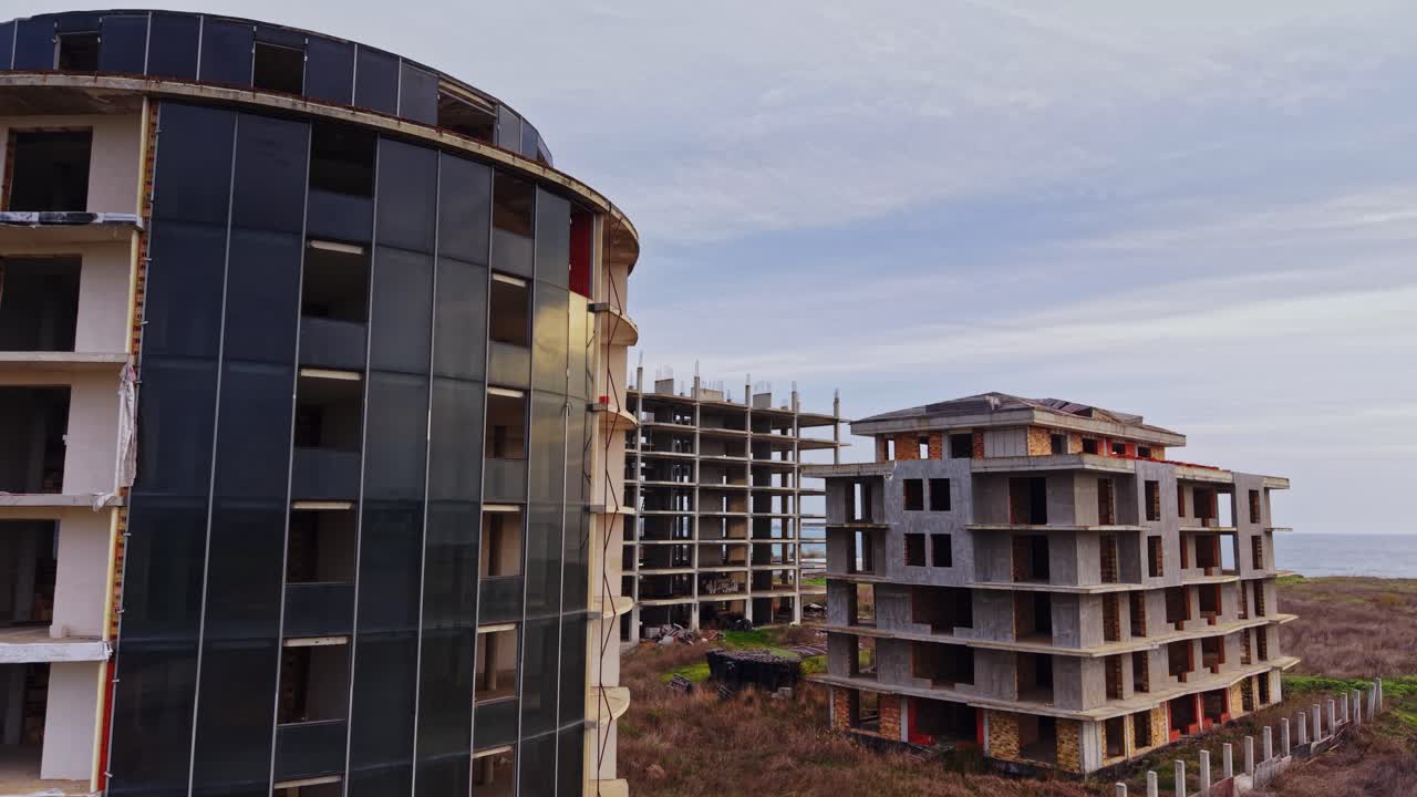 Abandoned buildings near the coastline with a cloudy sky above