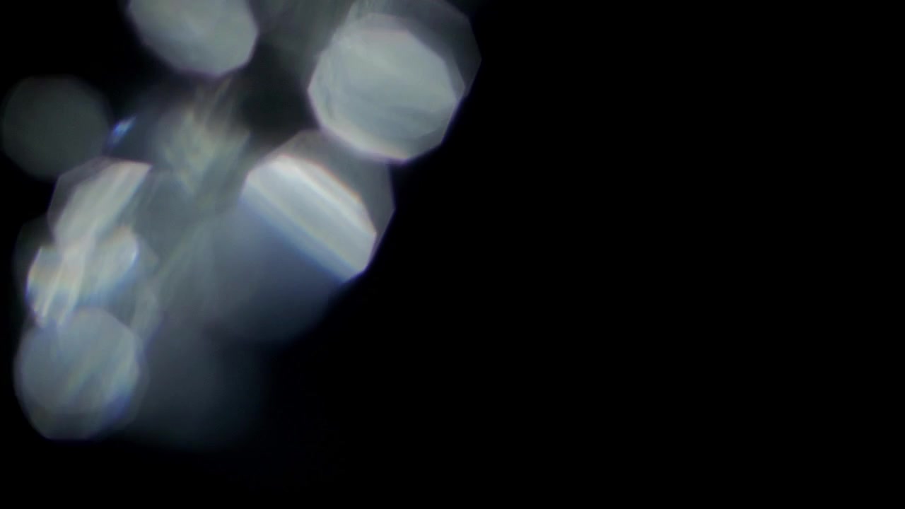 Fughe di luce dinamiche e bagliori dell'obiettivo bokeh su sfondo nero