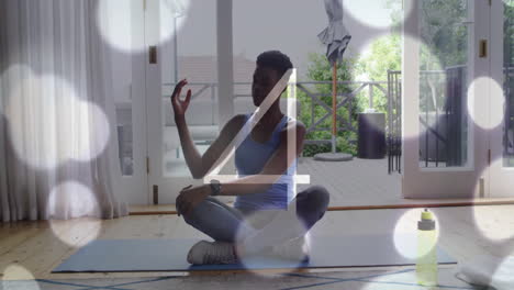 meditating on yoga mat, person with smartwatch over bokeh lights animation