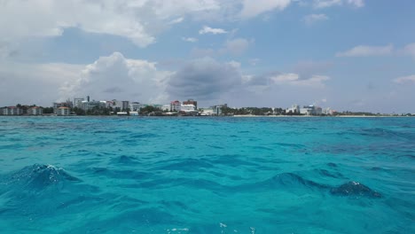 Vista-Barco,-Azules-Vibrantes-Del-Océano,-Paisaje-Urbano