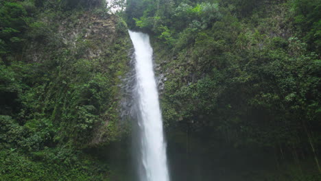 la fortuna waterfall flowing in the lush costa rica rainforest, tilt shot