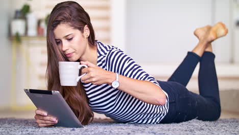 taking it easy with her tablet and a cuppa' joe