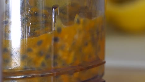 pulling the pulp of the passion fruit out of the shell into the mixer for processing