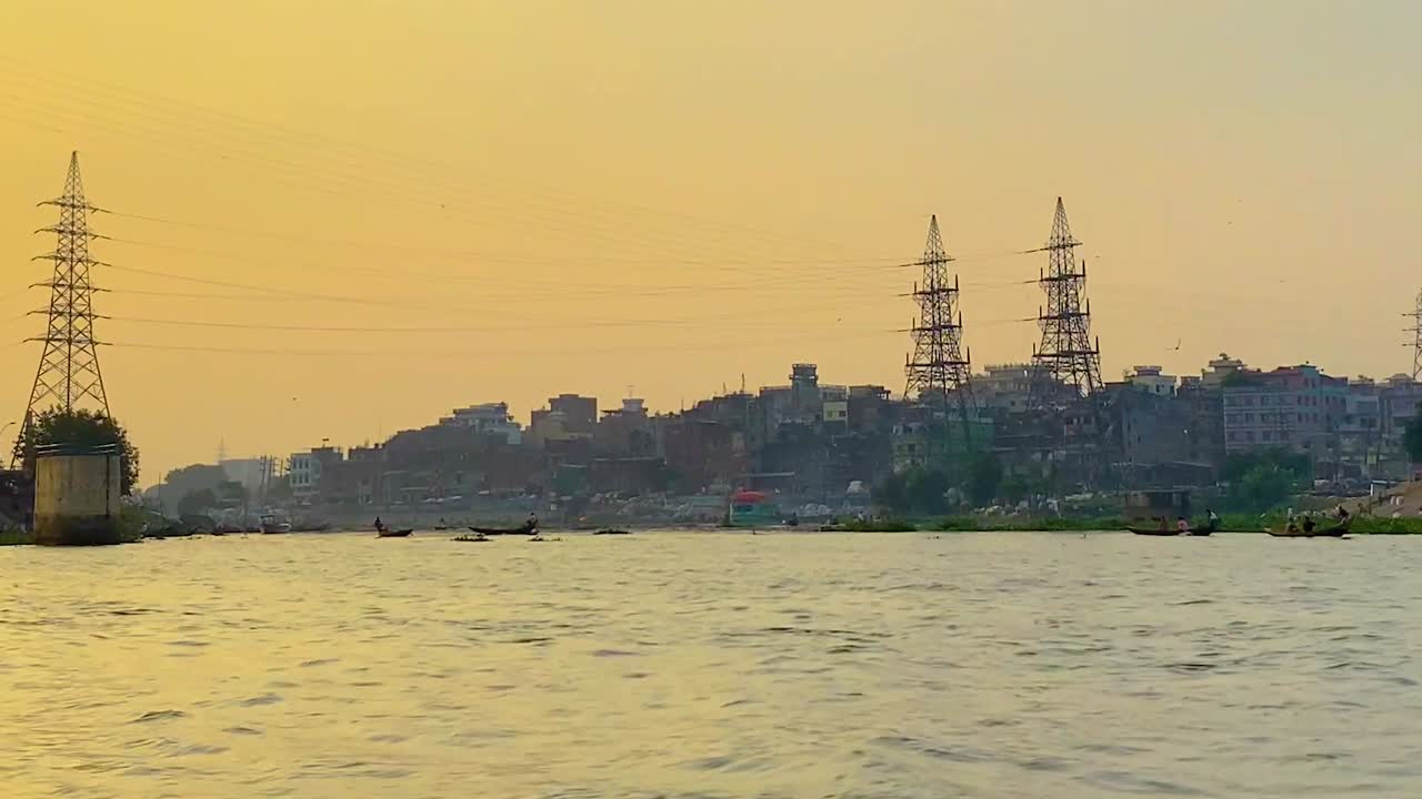 Barche di legno sul fiume Buriganga con lo skyline del lungomare di Dhaka, Bangladesh