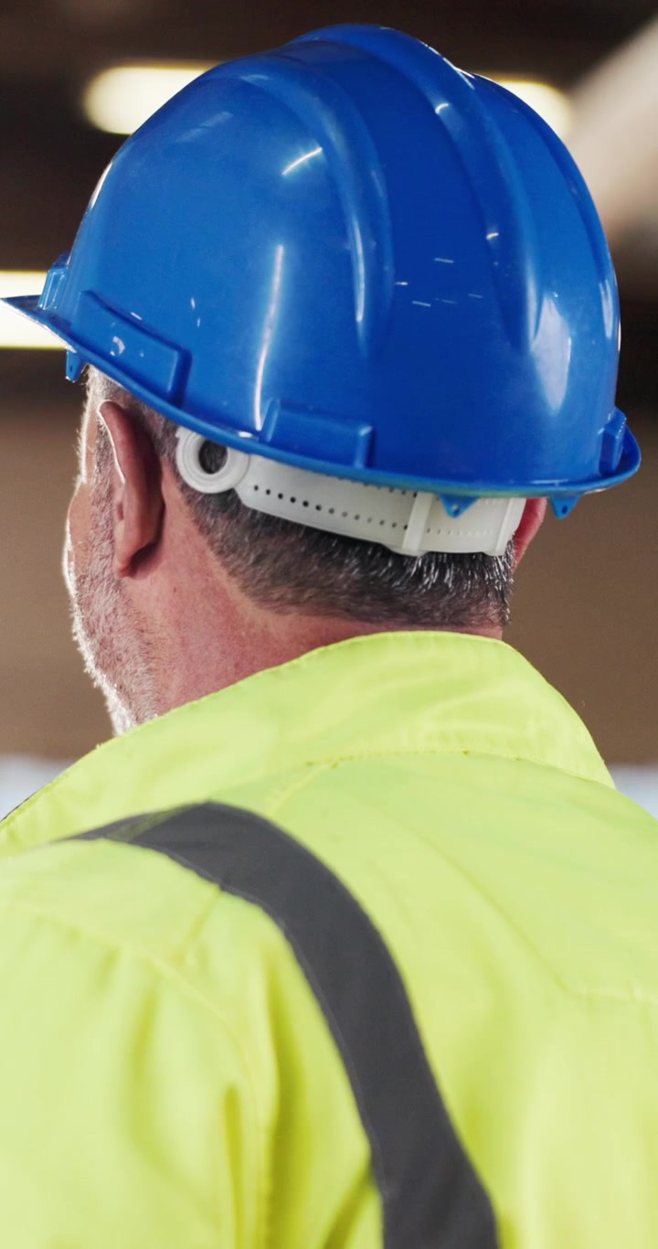 Operaio edile con casco blu e gilet ad alta visibilità