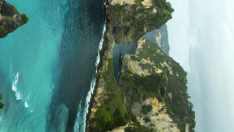 vista panorámica vertical de los hermosos acantilados frente a la playa de diamantes en nusa penida con vistas al mar azul en una hermosa mañana