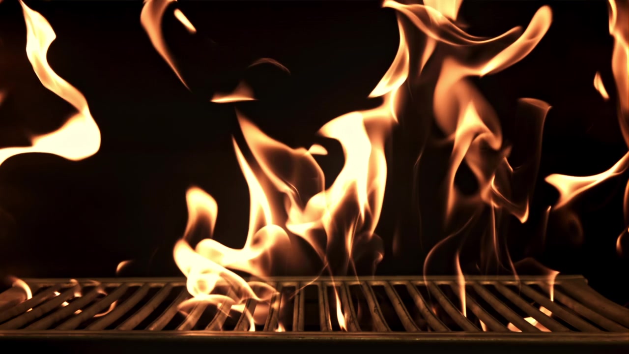 Fiamme al rallentatore che bruciano su una griglia BBQ vuota