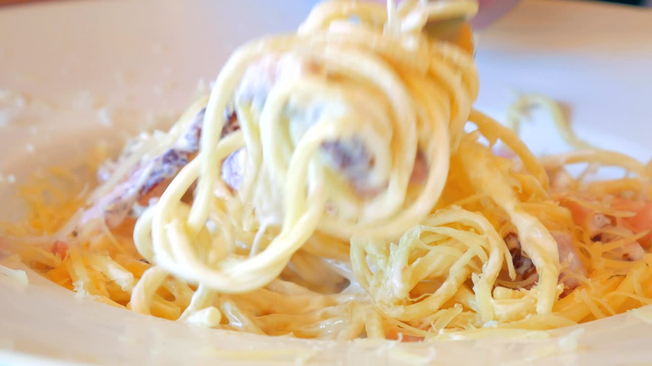 파르메산과 베이컨이 인 이탈리아 파스타 카르보나라를 가까이서 먹습니다.