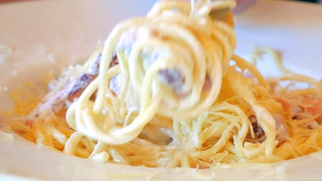 eating close up of italian pasta carbonara with parmesan and bacon.