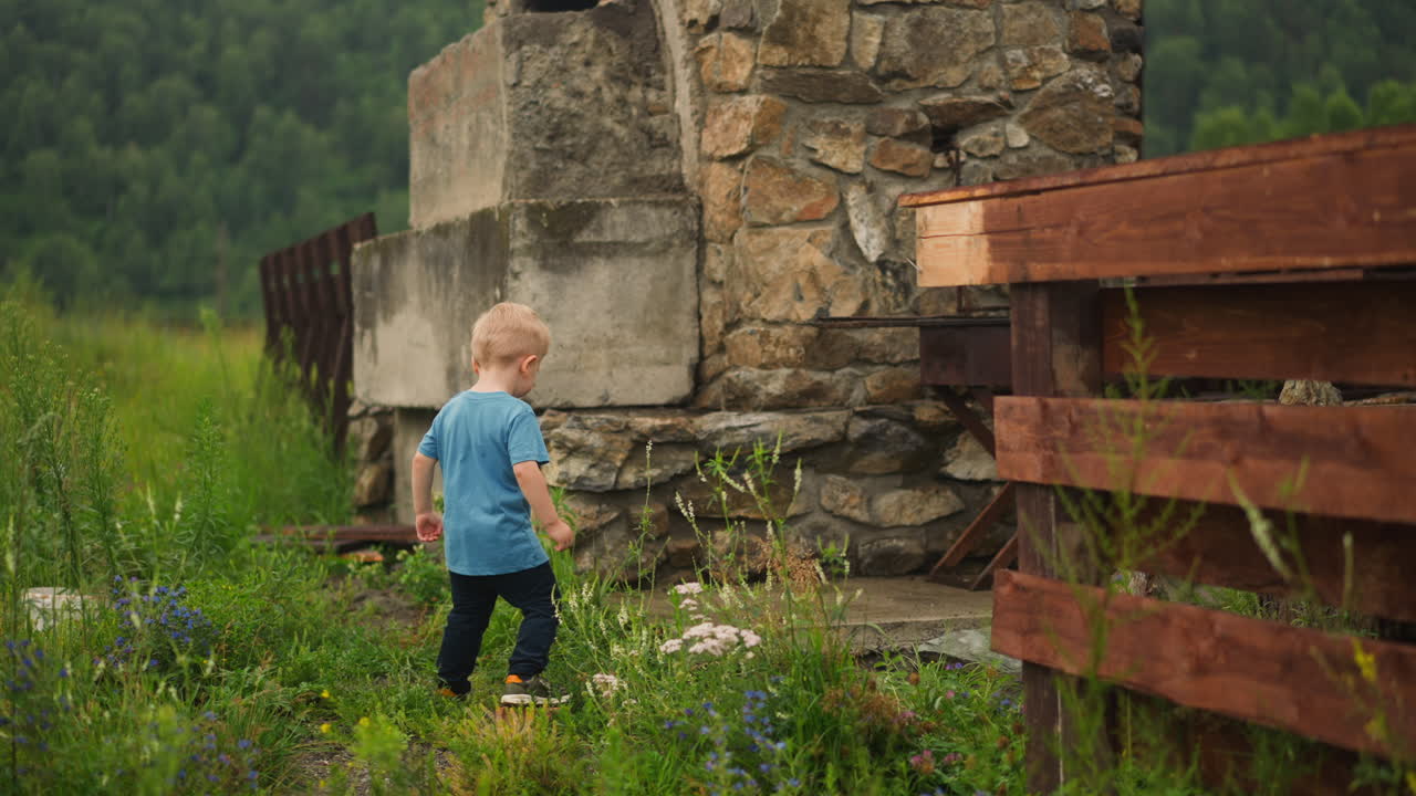 어색한 작은 소년은 마당에서 braizer를 위해 땅에 들어갑니다
