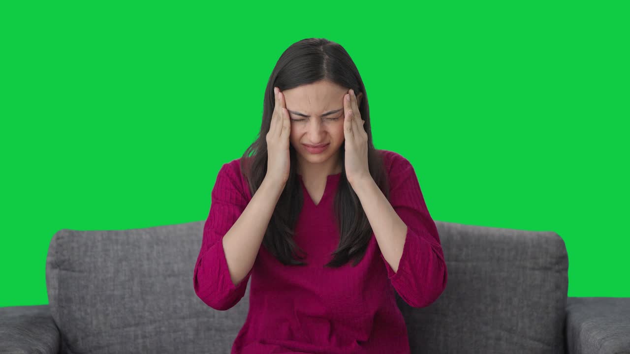 Sick Indian woman suffering from headache Green screen