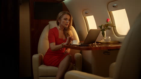 Attractive-businesswoman-having-video-call-on-corporate-first-class-trip-alone