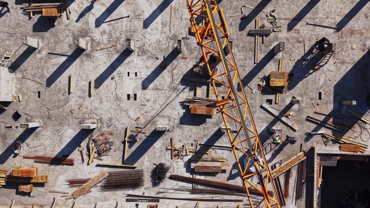 Aerial Top-Down View of Busy Construction Site with Workers and Crane