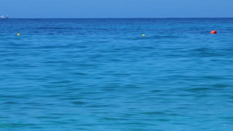 Boyas-Amarillas,-Bolas-De-Seguridad-Flotando-En-La-Costa-Del-Mar-Azul-En-El-Mediterráneo,-Señal-De-Territorio-Seguro-Para-Nadar,-Vacaciones-De-Verano