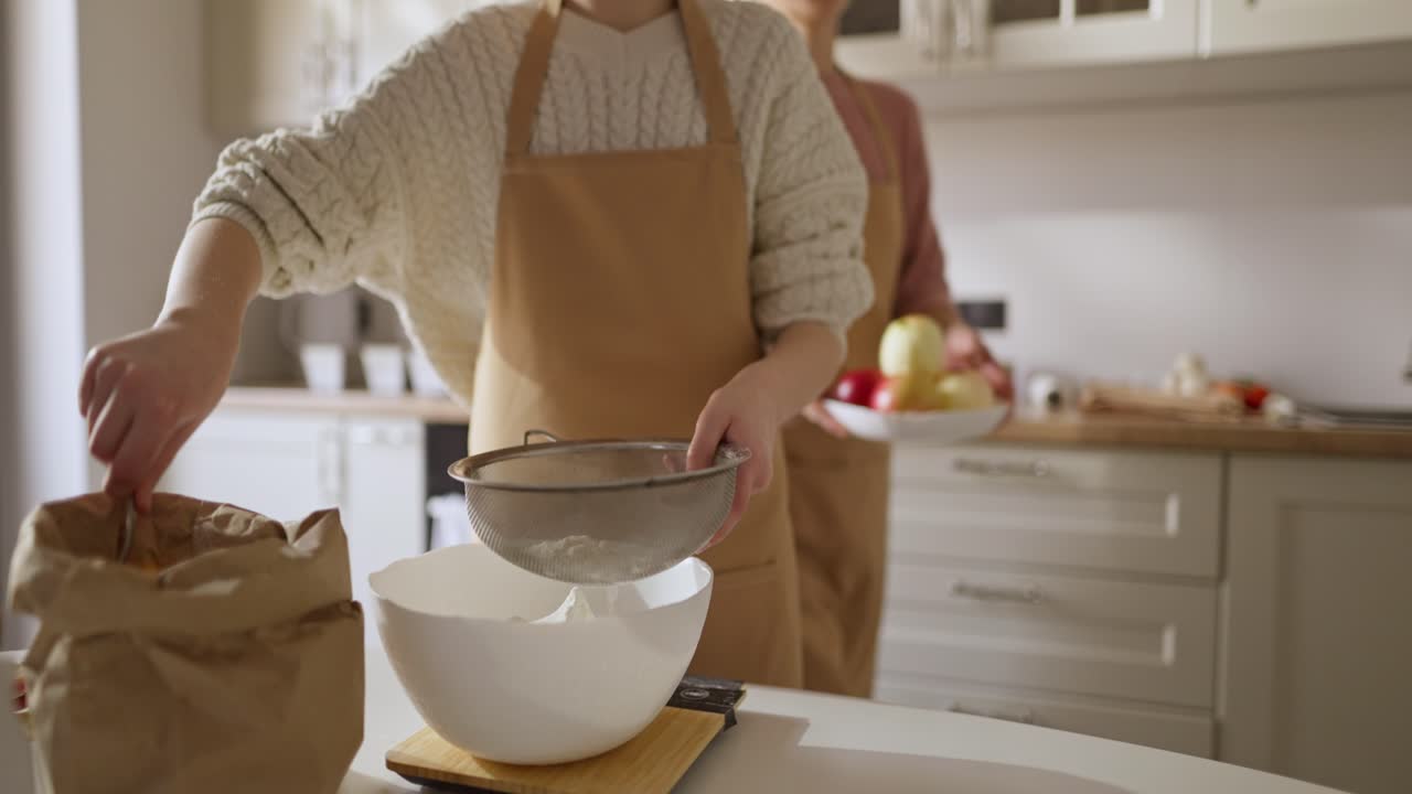 Woman sifting flour in the kitchen