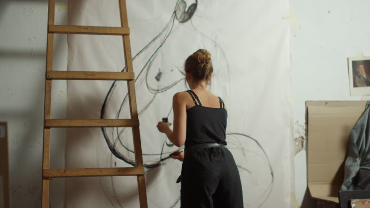 mujer talentosa dibujando en lienzo. pintor hábil pintando en interiores.