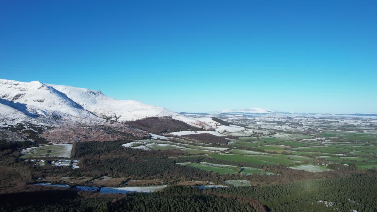 Ireland epic Locations Comeragh Mountains in snow with the lush farmlands of The Suir Valley on a tranquil winter day