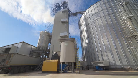 grain elevators under blue sky. huge metal grain storage tanks. silver containers. close-up.