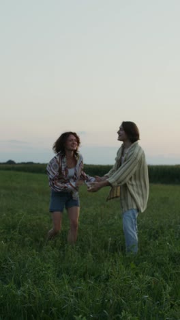 couple dancing in a field at sunset