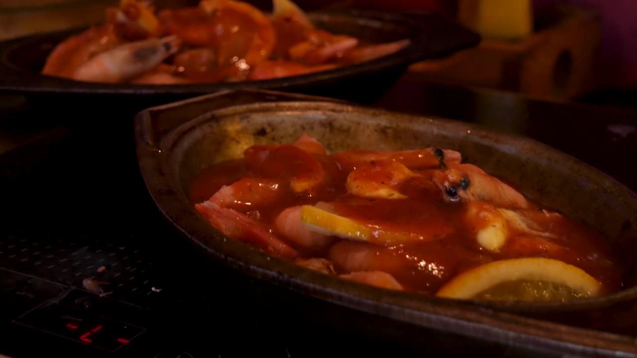 seguimiento suave en tiro sobre camarones con limones y salsa cajún picante en tazones de plata en una antigua cocina de campo