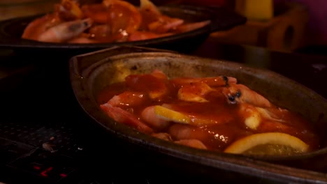 seguimiento suave en tiro sobre camarones con limones y salsa cajún picante en tazones de plata en una antigua cocina de campo