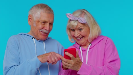 Senior-old-grandparents-pensioners-using-mobile-phone-typing-new-post,-browsing,-shopping-online