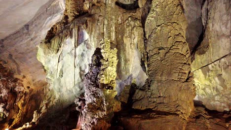 calcium stalagmites and cavern walls in phong nha cave, vietnam, tilt up reveal shot