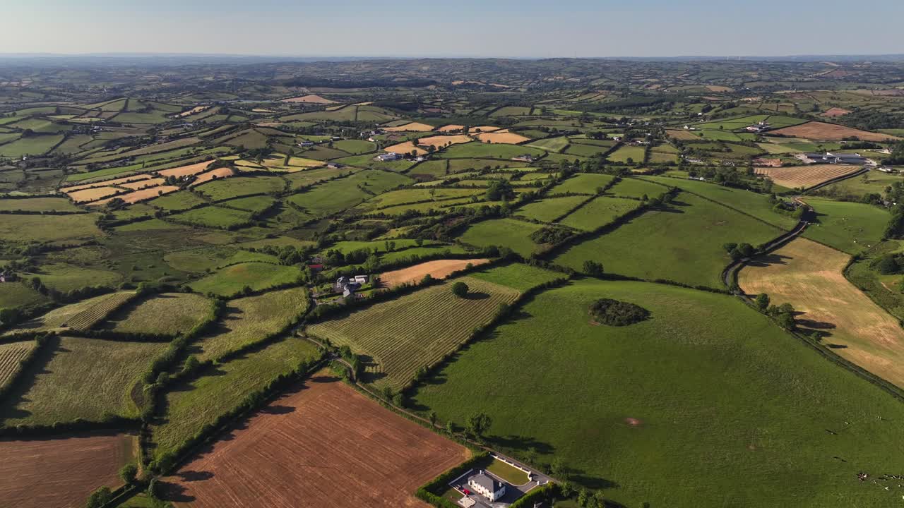 Corbeagh, County Cavan, Ireland, June 2023. Drone panoramic aerial establishing overview of pasture fields fit together like puzzle pieces, varying colors of green and brown fields