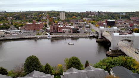 AERIAL OVER BRIDGE AND BOAT ALONG HUDSON RIVER IN TROY NY, NEW YORK