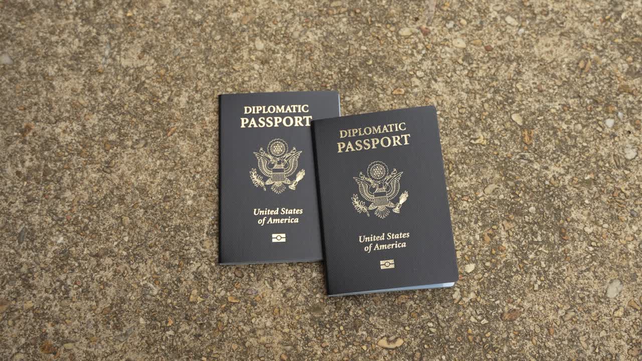 Two isolated American diplomatic passports on cement, no person