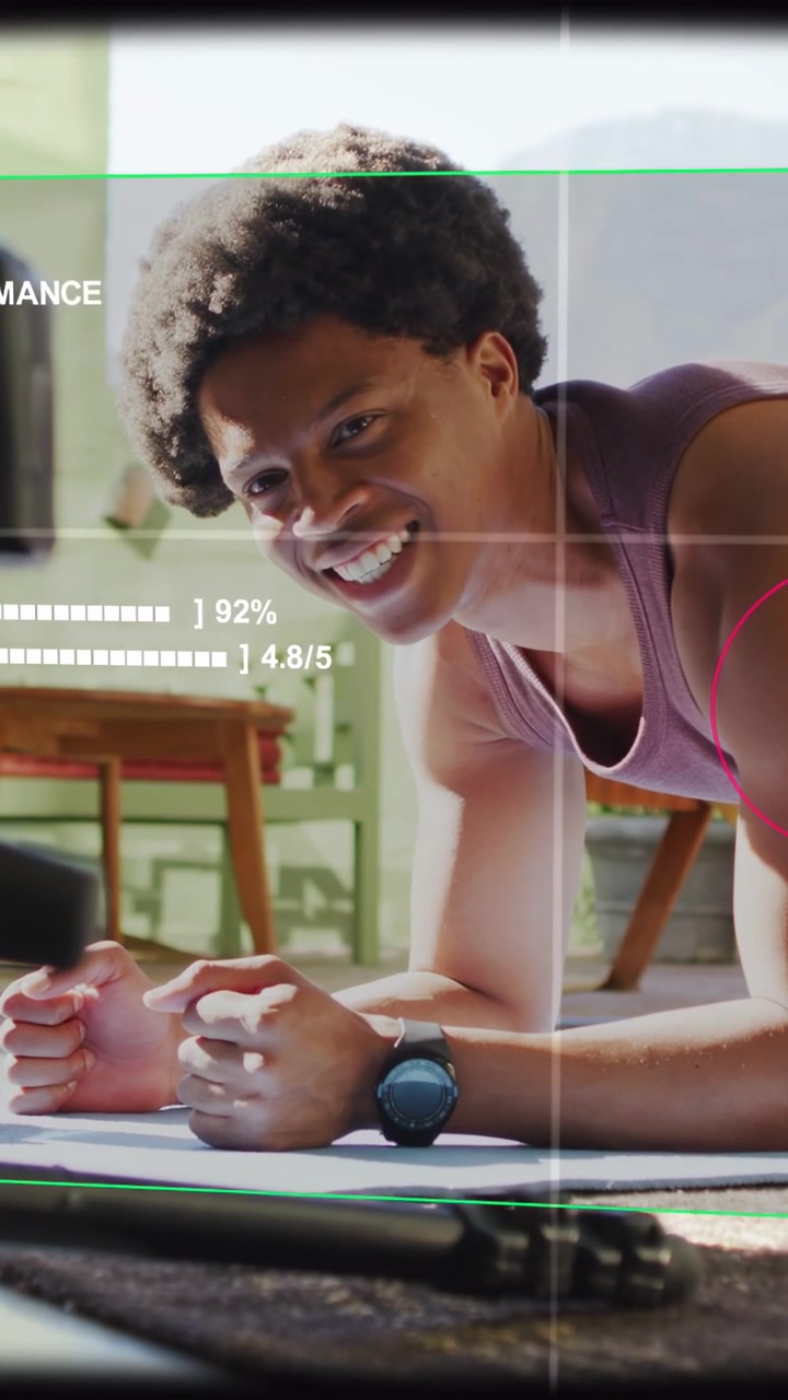 Vídeo vertical: Homem em prancha com antebraços seguindo instrução de aplicativo de fitness e monitorando métricas na tela.