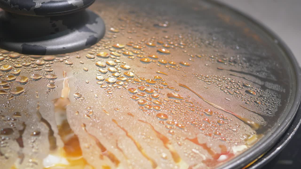 Close-up of a cooking pot with lid and condensation
