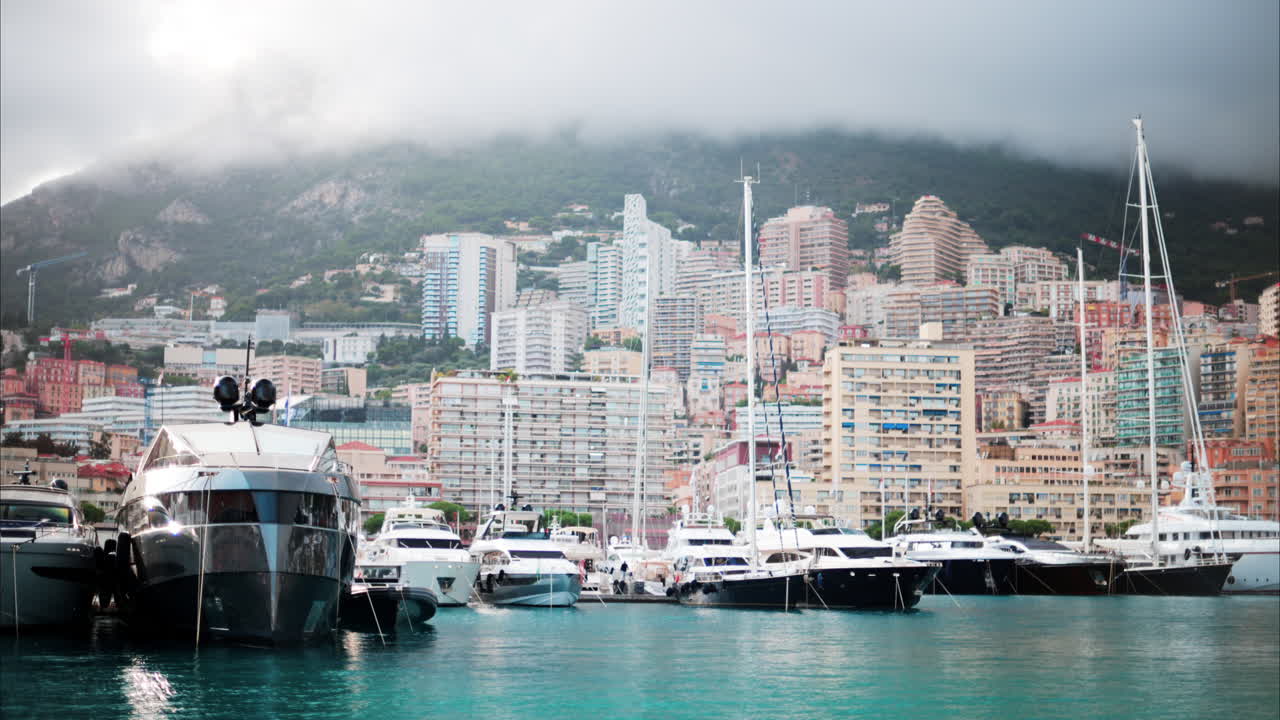 Vista delle barche ormeggiate nel porto turistico di Monaco con lo skyline della città sullo sfondo