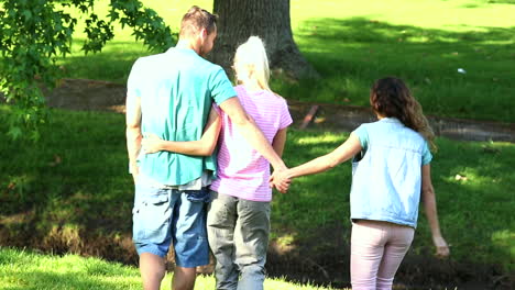 boy holding hands with another girl behind his girlfriends back