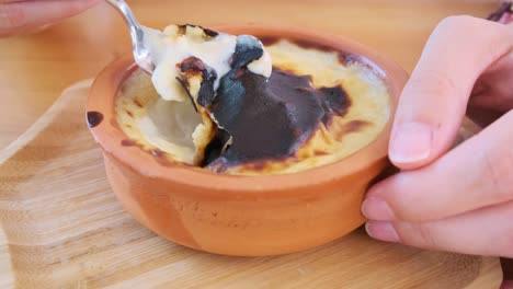 traditional turkish dessert - rice pudding sutlak, female hands eating in restaurant.