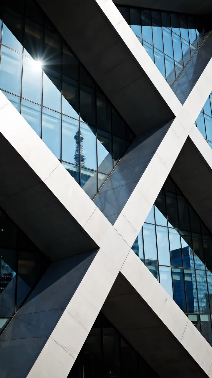 Facciata di edificio moderno con design geometrico e riflessi.