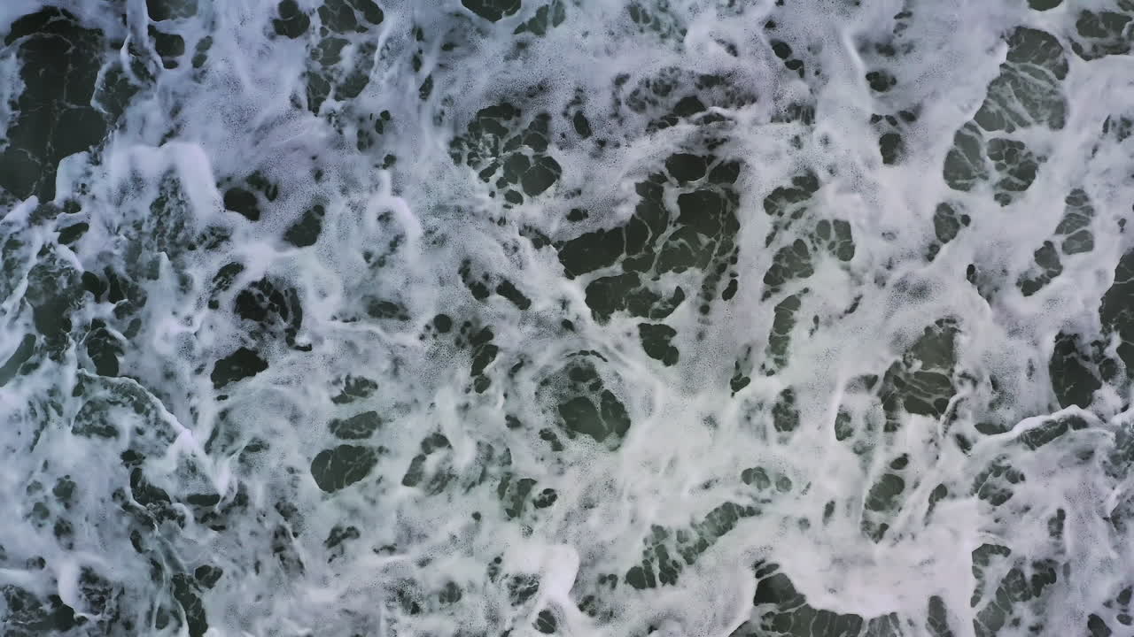 vista aérea de las olas violentas que se estrellan sobre la orilla del mar