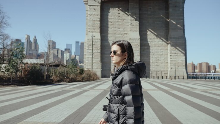 Woman Walking in New York City near a Bridge