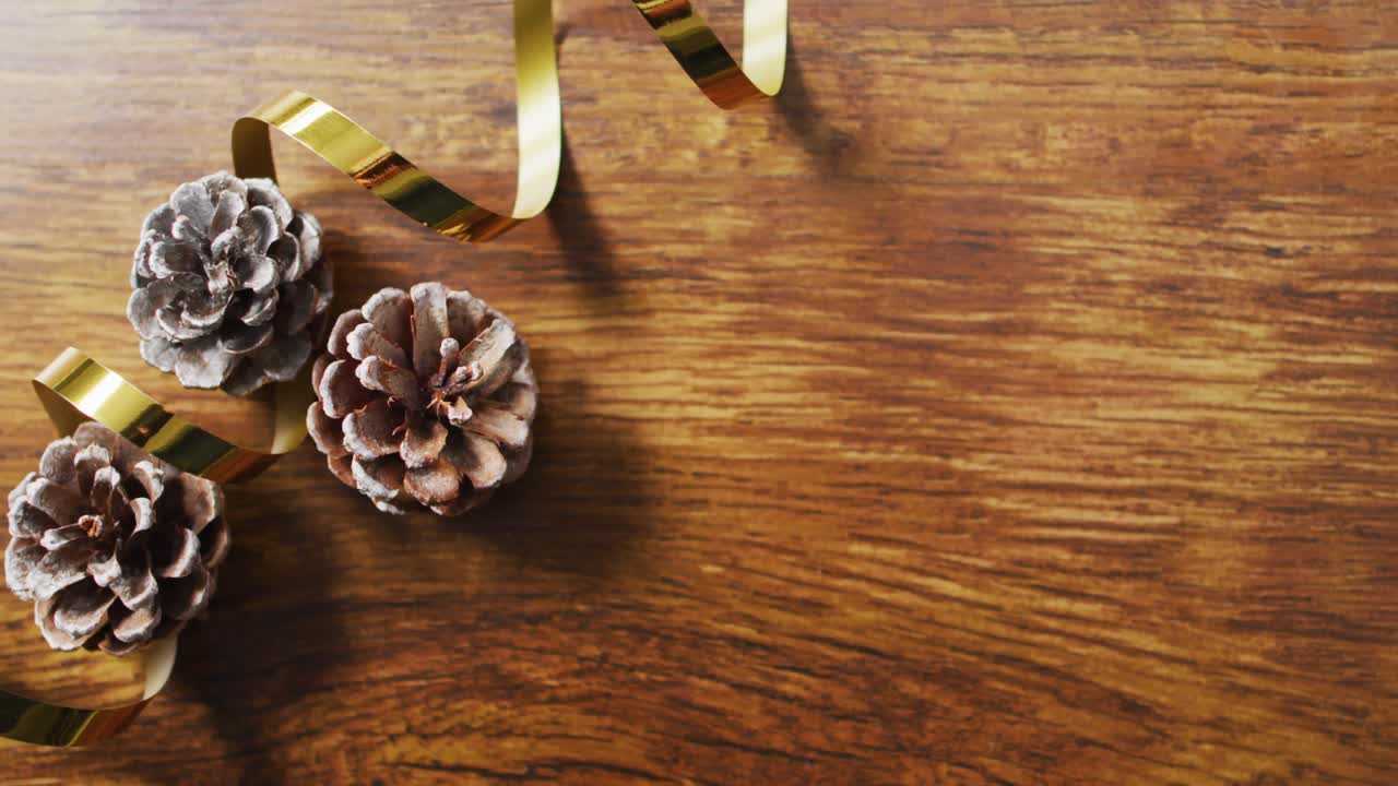 Video de decoraciones navideñas con piñas de pino y espacio para texto sobre fondo de madera
