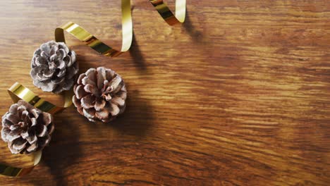 video of christmas decorations with pine cones and copy space on wooden background