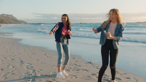 best friends blowing bubbles on beach at sunset teenage girls having fun summer playing by the sea enjoying friendship